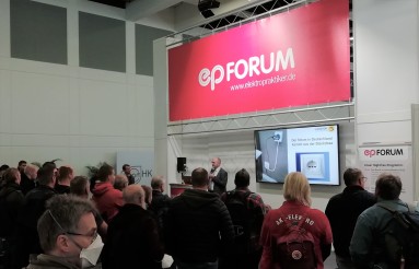 Ein Blick ins ep-Forum: rotes Banner mit weißer Aufschrift ep-Forum mit einem referierenden Mann am Rednerpult neben einem Monitor, wo seine Präsentation abgebildet wird, mehrere Fachbesucher hören zu Ein Blick ins ep-Forum: rotes Banner mit weißer Aufschrift ep-Forum mit einem referierenden Mann am Rednerpult neben einem Monitor, wo seine Präsentation abgebildet wird, mehrere Fachbesucher hören zu